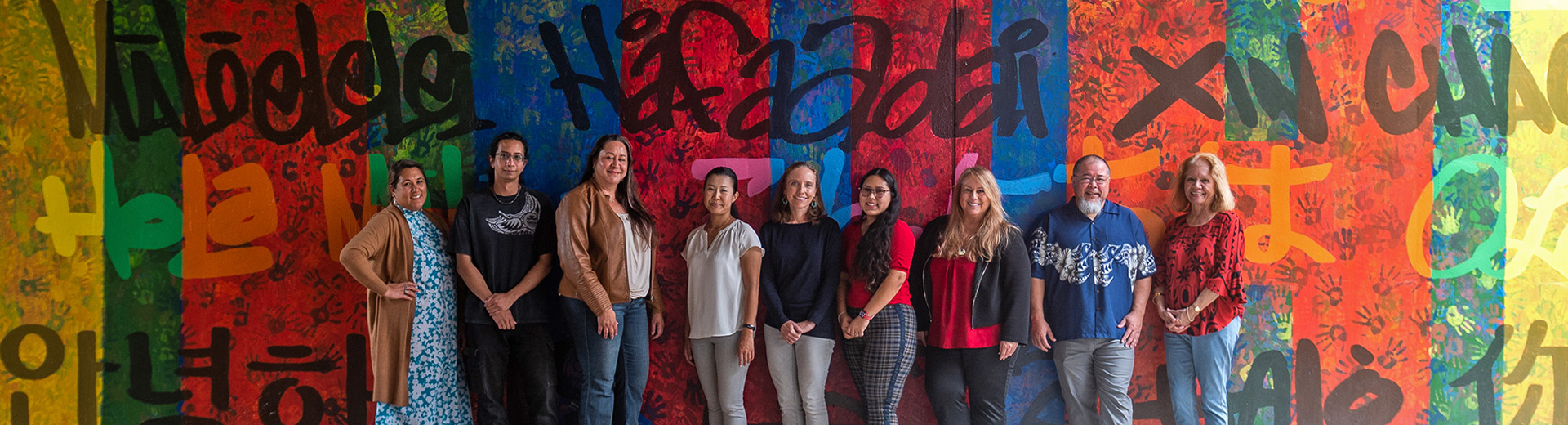 Group photo in front of multilingual mural